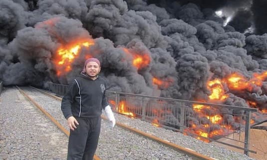 A Syrian rebel stands in front of a bombed oil pipeline in Baba Amr. AP