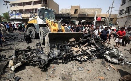 A bulldozer clears the wreckage from a car bomb in Baghdad earlier this month.  AFP file Photo.