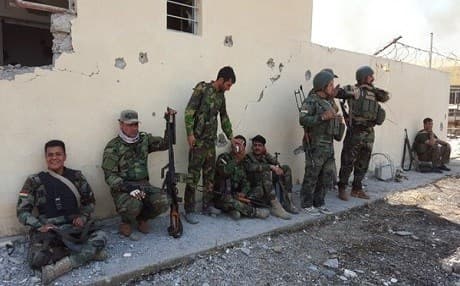 Peshmerga rest in the shade of a village school after reclaiming it from ISIS on Sunday. Photo: Ayub Nuri