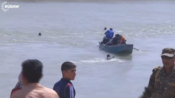 Residents fleeing Fallujah swim the Euphrates River in this image taken from a Rudaw video.