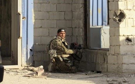 An Iraqi army soldier takes cover  during the battle for Fallujah. AP file photo 