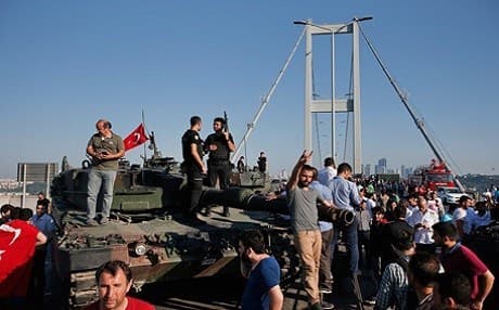 People gather for celebration around Turkish police officers, loyal to the government, standing at the top of tanks abandoned by Turkish army officers following a coup attempt. Photo: AP