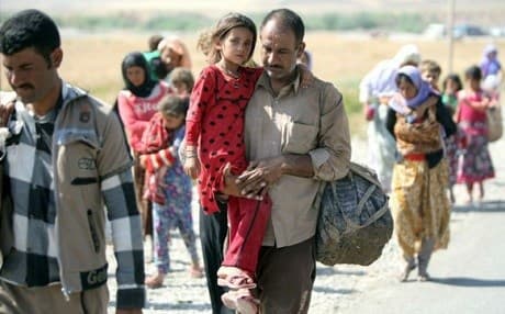 A Yezidi carries his man as they flee the Islamic State on August 11, 2014. Photo: Ahmad al-Rubaye/AFP