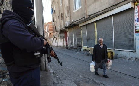 A resident of Diyarbakir walks past a Turkish soldier in the centre of the city on March 17, 2016. Photo: Ilyas Akengin/AFP