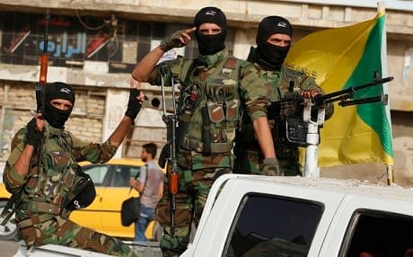 Forces of the Shiite militia group Ketaeb Hezbollah drive through Baghdad’s Karada neighbourhood. Photo: AFP
