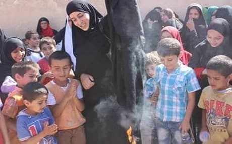 A woman who escaped Manbij burns the black clothing mandatory under Islamic State rule. Photo: Shervan Derwish/facebook