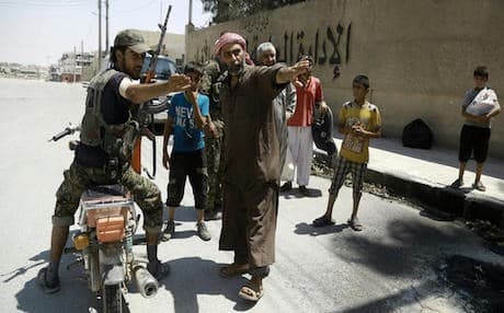 A member of the Syrian Democratic Forces (SDF) showing fleeing civilians a safe street in Manbij. AFP photo