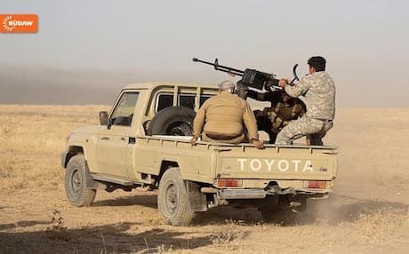 A Peshmerga soldier fires on ISIS militants at a village on the Khazir front.