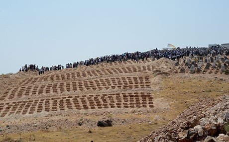 People wait close to empty graves at a cemetery during the funeral for the victims of Saturday night's attack on a wedding party that left 51 dead in Gaziantep. AFP photo.