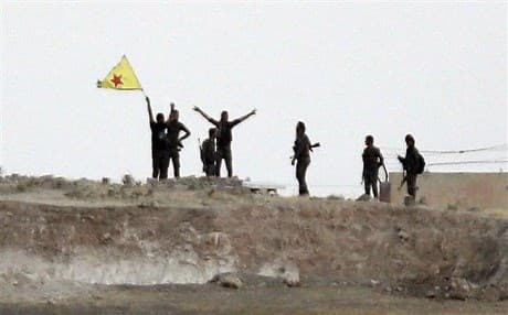 YPG fighters wave their yellow flag on the outskirts of Tal Abyad in Syria. AP file photo