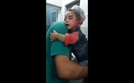 A child cries and clings to a nurse in a hospital in Aleppo. Photo: SAMS video