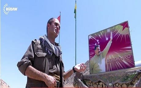 Agid Civian, the commander of the Kurdistan Workers Party (PKK) in the Yezidi town of Shingal next to a portrait of the PKK leader Abdullah Ocalan. Photo: Rudaw