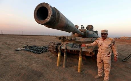 An Iraqi soldier poses with a tank and ammunition seized from ISIS militants. Photo: Safin Hamed/AFP