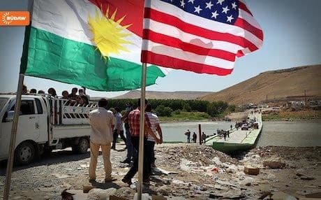 The Kurdish and US flags welcome Yezidi-Kurdish civilians rescued from ISIS into the Kurdistan Region. The US has provided military support to Erbil since ISIS intensified its military campaign across Iraq more than two years ago.