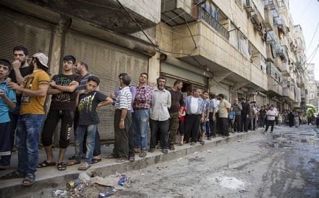 Residents of eastern Aleppo lined up for bread in July. Photo: AFP