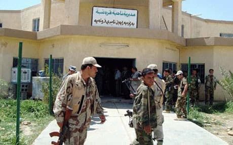 Peshmerga guard a municipality building in Qaratapa. Rudaw photo