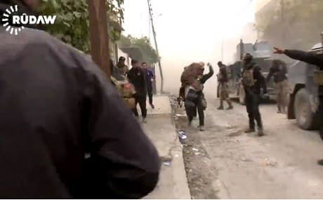 An Iraqi soldier carries a person injured by an ISIS mortar in Mosul’s Masarif district on Wednesday. Photo: Rudaw video