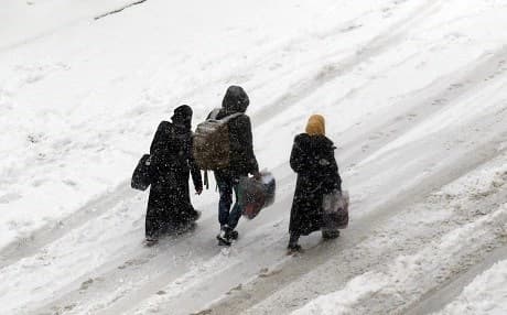  Syrians walk in a snow covered street in the town of Maaret al-Numan, in Syria's northern province of Idlib, on Wednesday. Rebels and civilians who have sought refuge in the opposition-held province of Idlib, most recently from second city Aleppo, say they are suffering from skyrocketing prices and overpopulation. Photo:AFP