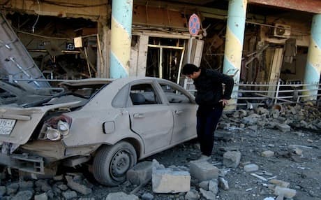 A man inspects his destroyed car after a deadly bomb attack in Kirkuk, Jan. 2013. Photo: AP