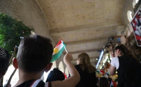 A Kurdish boy walks through Erbil's downtown market waving the Kurdish flag. Photo by Farzin Hassan/Rudaw