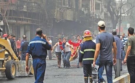 Iraqis evacuate a body from the site of a suicide car bombing in Baghdad. AFP file photo