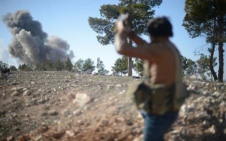 A member of the Free Syrian Army watches smoke rising during an attack on ISIS positions near al-Bab on February 2. Photo: Huseyin Nasir/AA