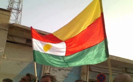Kurdistan and PYD flags sown together and waved on the streets of Kobane on the day of its liberation from ISIS in July 2012. The liberation of the city from the ISIS militants remains a unique moment in the modren Kurdish history whereby Kurdish groups from different parts of Kurdistan came together to fight against their common enemy. Photo: dimoqrati.info