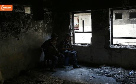 Two Iraqi army soldiers on guard duty at a ruined building in west Mosul. 