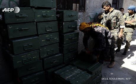 Syrian Democratic Forces unloaded boxes of ammunition, supplied by the US-led coalition in a village north of Raqqa. Photo: Delil Souleiman | AFP