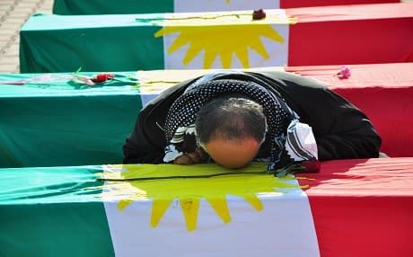 A Kurdish man shows respect to the dead bodies of the victims of the Kurdish genocide of Anfal killed in late 1980s and returned to Kurdistan in 2012. File photo: Rudaw/Sartip Othman