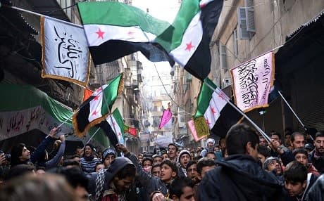 Secular demonstrators in Aleppo wave the old Syrian flag that has became the symbol of their opposition movement. Aamir Qureshi | AFP
