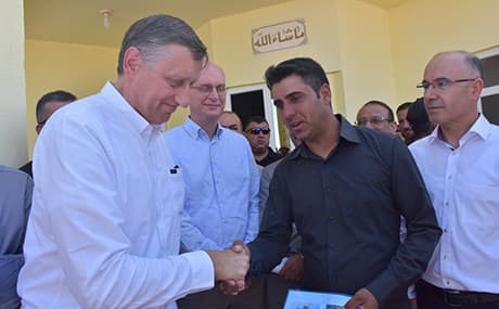 German Ambassador Cyrill Nunn shakes the hand of a Yezidi man whose family has been given the ownership deed of their property. Photo: German Consulate in Erbil, @GermanyInKRI
