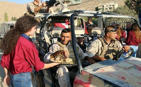 A girl serves pastries to Lebanese Army soldiers during a celebration of their return from battling ISIS group on the country's eastern front bordering Syria, in the eastern town of Ras Baalbek on August 30, 2017. Photo: AFP