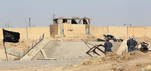 Kurdish Peshmerga forces (back) hold their position on a river bank across from Iraqi forces on the southern outskirts of Kirkuk. October 14, 2017 / Photo: AFP / Ahmad al-Rubaye