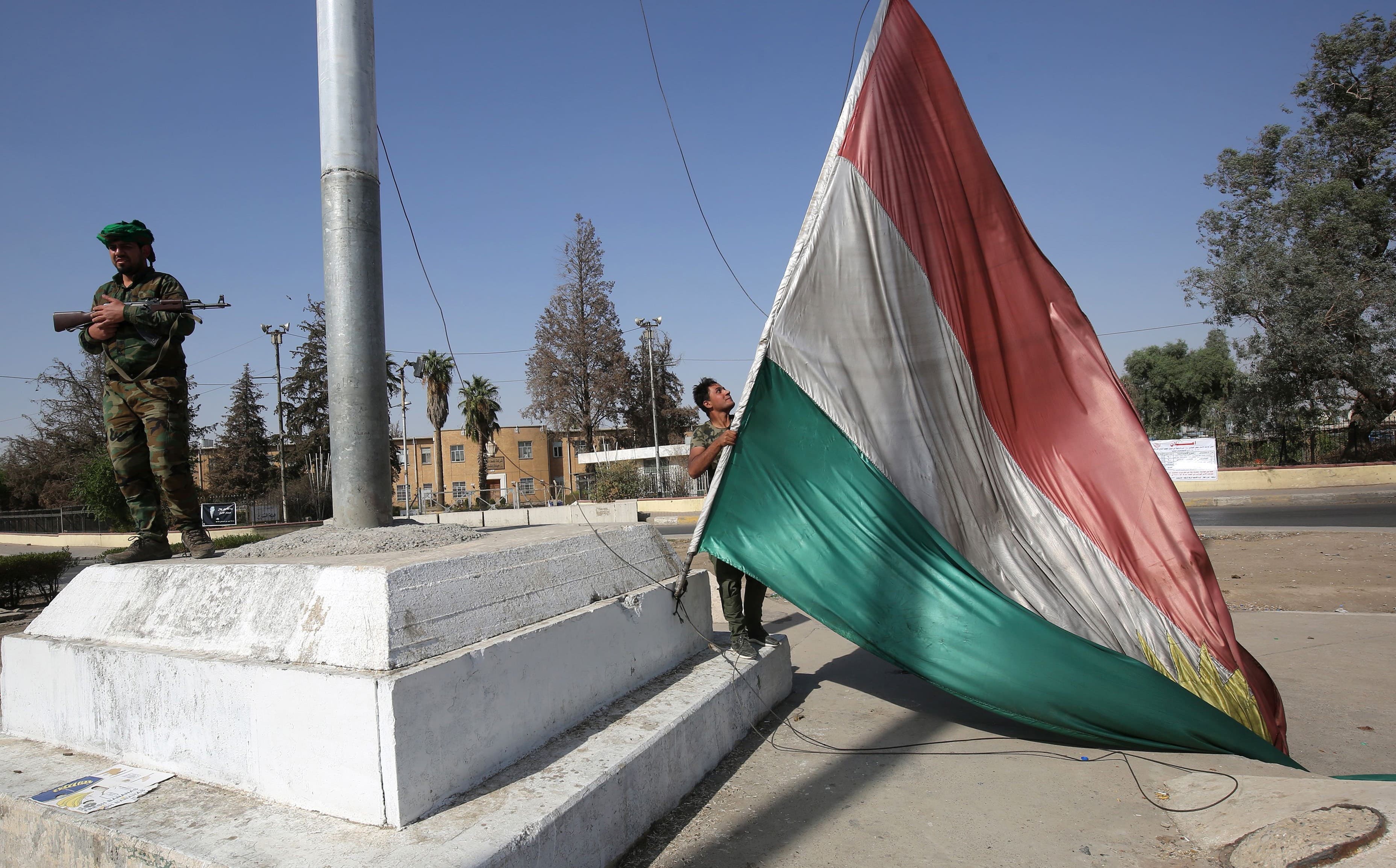 A member of the Iraqi forces takes down a Kurdistan flag in the centre of Kirkuk on Monday. Photo: Ahmad al-Rubaye/AFP