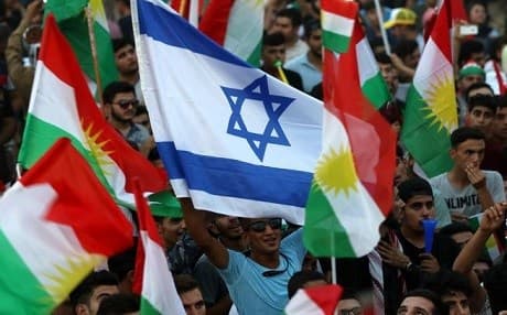A picture taken on October 21, 2017, shows a man holding an Israeli flag alongside the flag of Kurdistan Region during a demonstration outside the UN Office in Erbil. Photo: AFP Photo/Safin Hamed