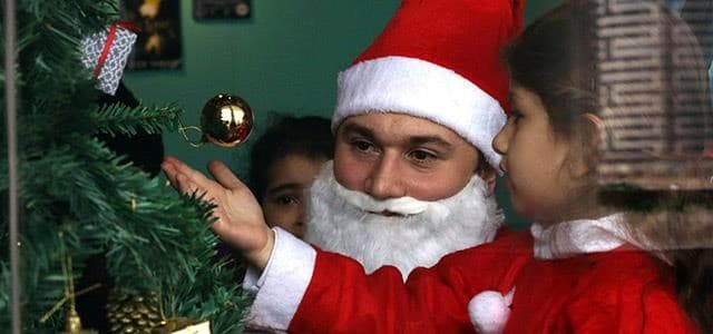 A man dressed as Santa Claus plays with a child during a Christmas event at the Book Cafe in Erbil on December 23, 2017. Photo: AFP/ Safin Hamed 