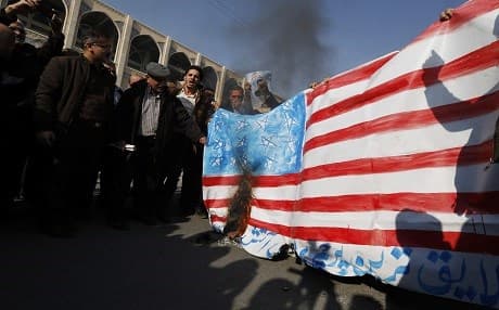 Pro-government demonstrators set a makeshift US flag on fire during a march after the weekly Muslim Friday prayers in Tehran on January 5, 2018. New pro-regime protests were held in Iran, in reaction to the protests against the government and the cost of living. Photo: AFP/Atta Kenare