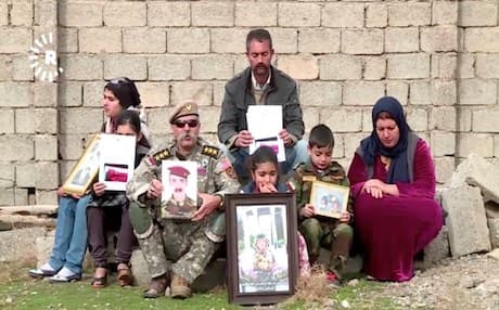 Family members of missing Peshmerga Hassan Mohammed Hashim hold his photograph, demanding the KRG, Iraqi government and international bodies help free their son who they claimed was in Iraqi custody. Photo: Rudaw video