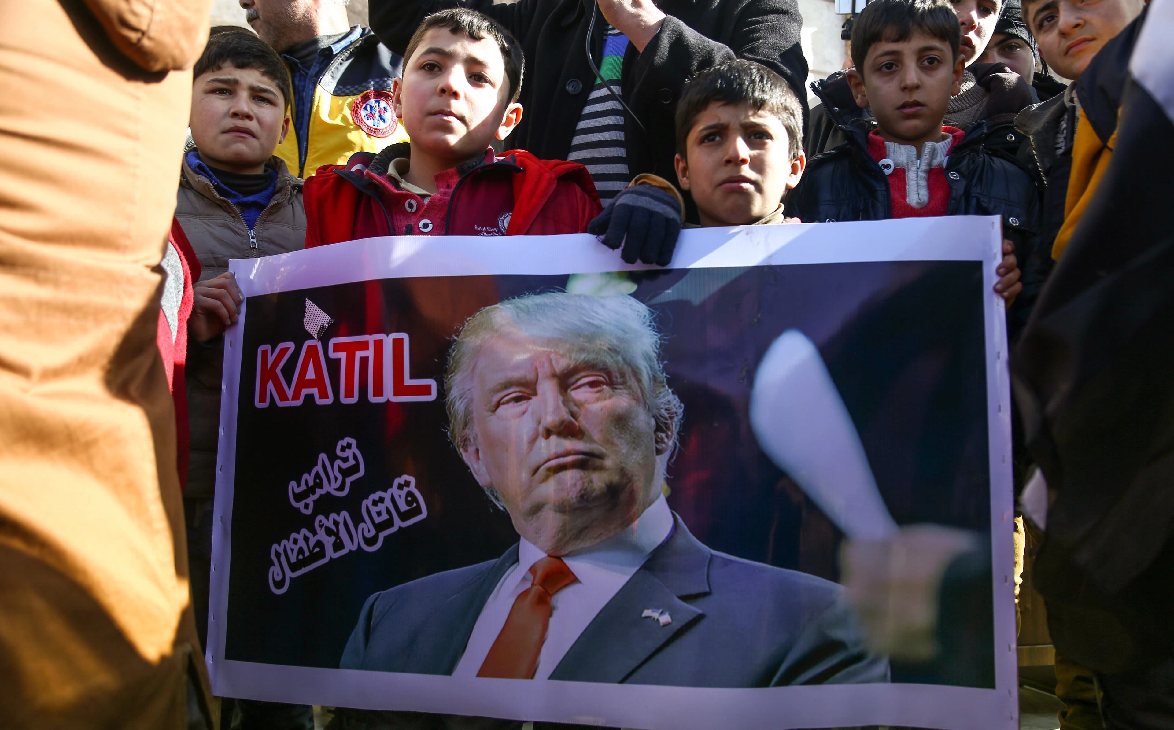Syrian children in rebel-held Azaz, northern Syria hold a banner reading ‘Killer – Trump is a killer of children’ during a demonstration in support of Turkey’s military operation in Afrin on Friday. Photo: Nazeer al-Khatib/AFP