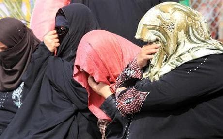 Iraqi female detainees hide their faces. Photo AFP