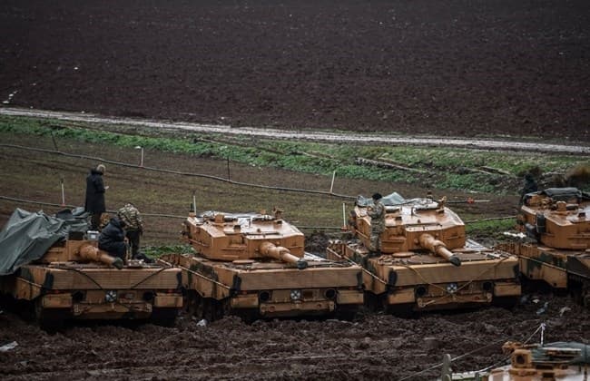 Turkish soldiers stand on tanks stationed in a field near the Syrian border at Hassa, in Hatay province on January 25, 2018. Photo: Ozan Kose | AFP