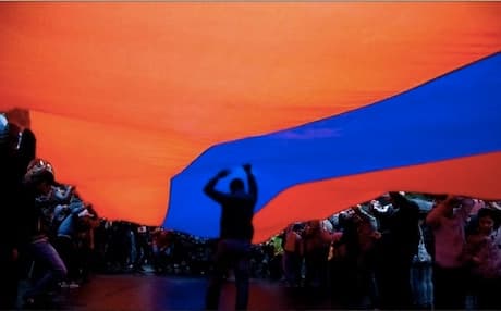 Armenians hold their national flag at the Genocide Memorial in the capital Yerevan. Photo: aspar.com
