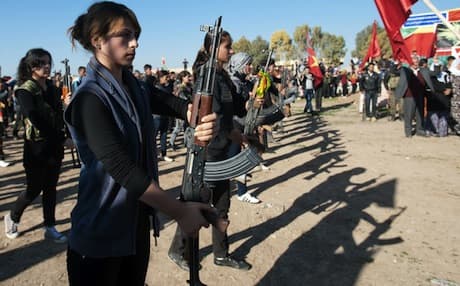 Syrian Kurdish women and members of the Peoples Protection Units stand guard at the funeral of one of their comrades in Qamishli. Photo: AFP