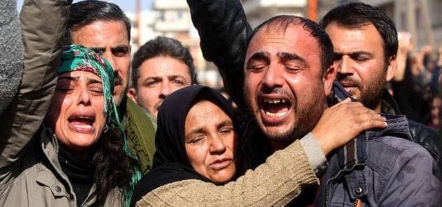 A picture taken on February 3, 2018, in the town of Afrin shows the mother (C), brother (R) and sister (L) of the late 23-year-old YPJ fighter Barin Kobani, attending a mourning ceremony in her honor, after the YPJ and the Syrian Observatory for Human Rights accused Turkish-backed Syrian rebels of filming her mutilated dead body. Photo: AFP/Delil Souleiman
