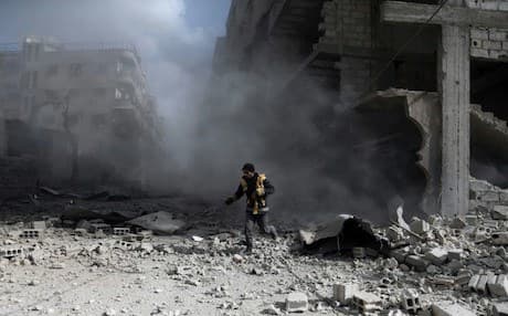 A civil defence volunteer checks the site of a regime air strike in the rebel-held town of Saqba, in the besieged Eastern Ghouta region on the outskirts of the capital Damascus, on February 23, 2018. Photo: AFP/Abdulmonam Eassa 