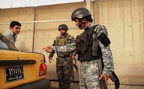 In this undated photo an Iraqi police officer searches a car in Baghdad, Iraq. Photo: Spencer Platt | AFP