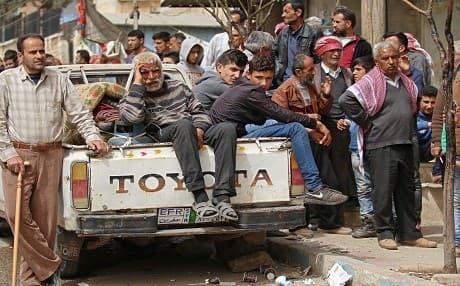 Syrian civilians sit in the back of a pick-up truck in Afrin on March 22, 2018. Photo: Aaref Watad | AFP 
