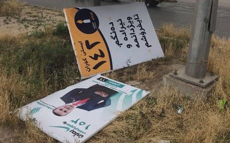 Campaign posters blown over in the wind lie on the side of an Erbil street. Photo: Rudaw
