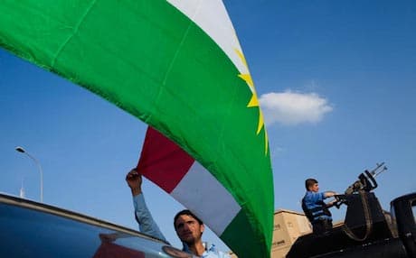 A Kurdish man in Kirkuk flying the Kurdistan flag over his car. Photo: AFP